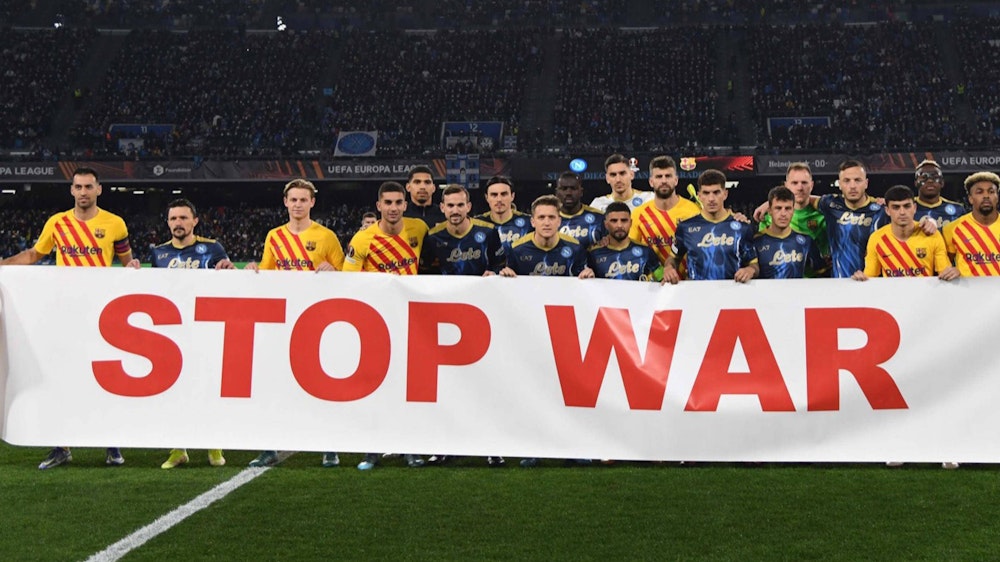 Spieler des FC Barcelona und des SSC Neapel mit einem Banner gegen den Ukraine-Krieg.