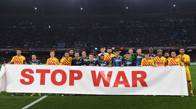 Spieler des FC Barcelona und des SSC Neapel mit einem Banner gegen den Ukraine-Krieg.
