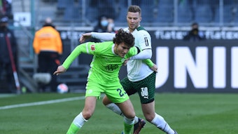 Nico Elvedi, Abwehrspieler von Borussia Mönchengladbach, im Zweikampf mit Wolfsburg-Profi Jonas Wind während des Bundesliga-Duells am 26. Februar 2022 im Borussia-Park. Wind schirmt den Ball ab.