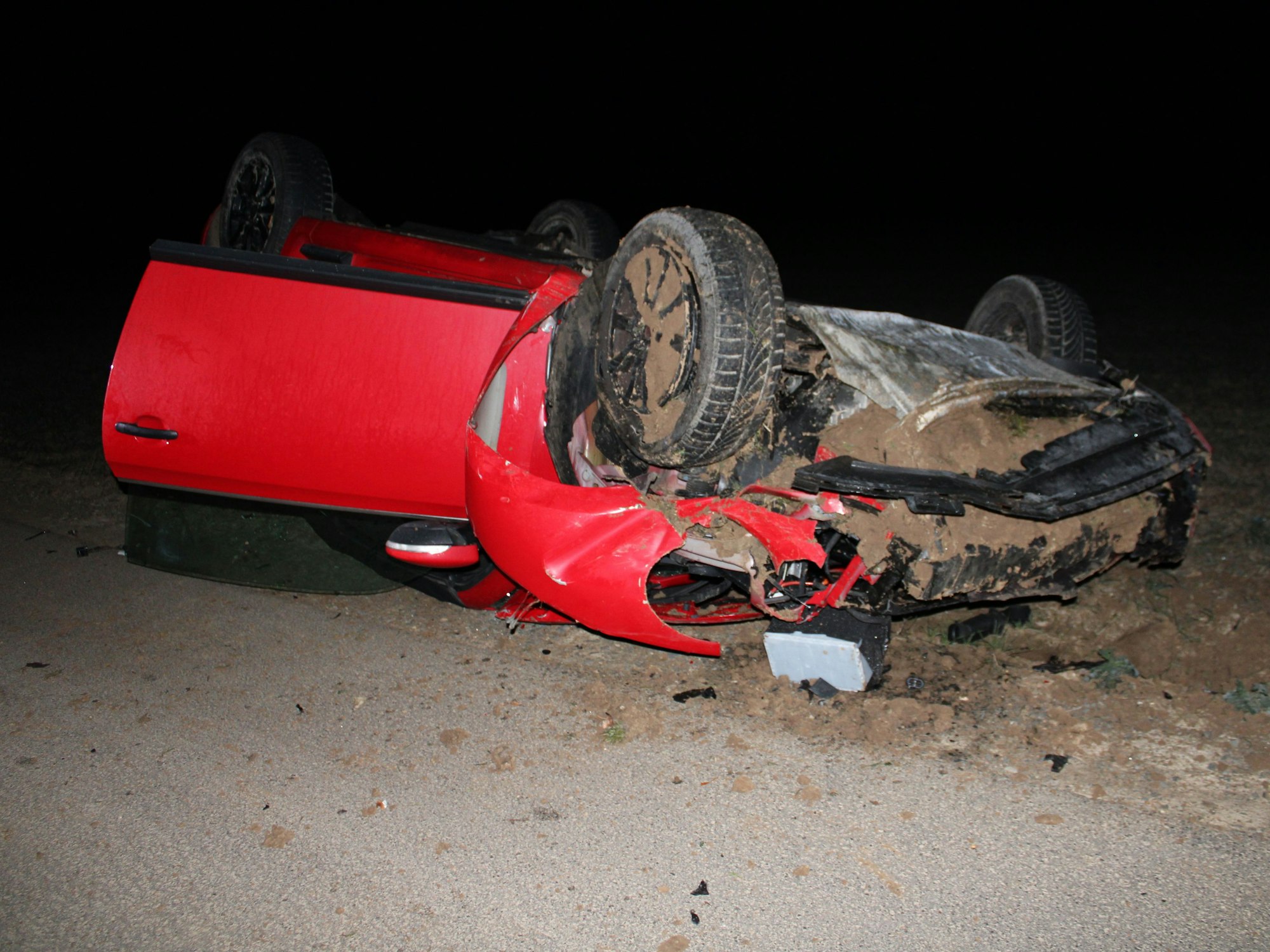 Ein rotes Auto überschlug sich und liegt auf einem Feld in Vettweiß.