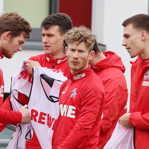 Luca Kilian, Dejan Ljubicic, Florian Kainz und Tim Lemperle ziehen sich beim Training es 1. FC Köln (22. Februar 2022) Leibchen an.