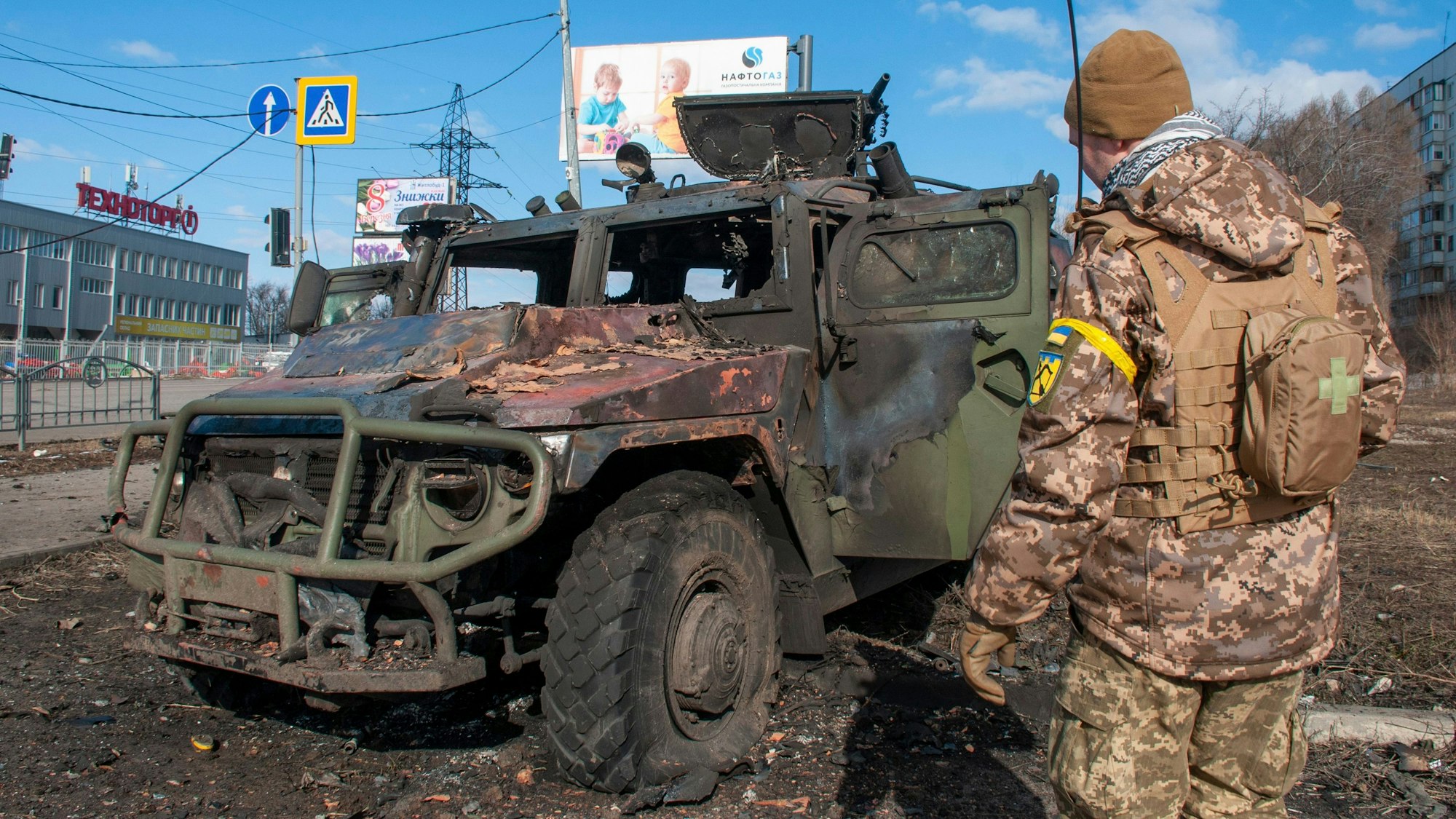 Ein ukrainischer Soldat inspiziert ein beschädigtes Militärfahrzeug.