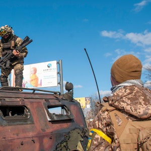 Ukrainische Soldaten inspizieren ein beschädigtes Militärfahrzeug nach Kämpfen in Charkiw.