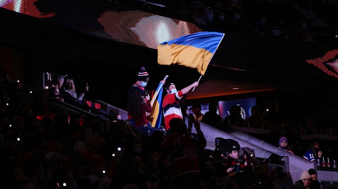 Ein Fan schwenkt eine Flagge der Ukraine während des NHL-Spiels zwischen den Ottawa Senators und den Montreal Canadiens.