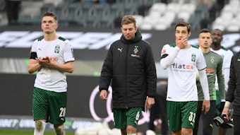 Matthias Ginter , Christoph Kramer und Florian Neuhaus von Borussia Moenchengladbach am 26.02.2022 nach dem Spiel gegen den VfL Wolfsburg mit hängenden Köpfen beim Applaudieren der Fans.