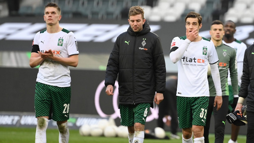 Matthias Ginter , Christoph Kramer und Florian Neuhaus von Borussia Moenchengladbach am 26.02.2022 nach dem Spiel gegen den VfL Wolfsburg mit hängenden Köpfen beim Applaudieren der Fans.