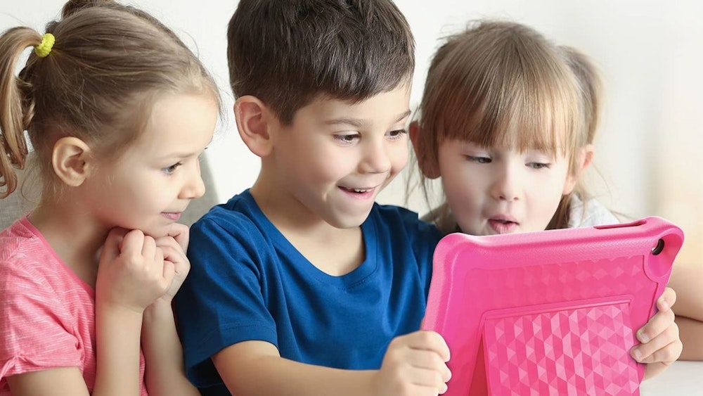 Drei Kinder gucken aufgeregt auf ein pinkes Kinder-Tablet.