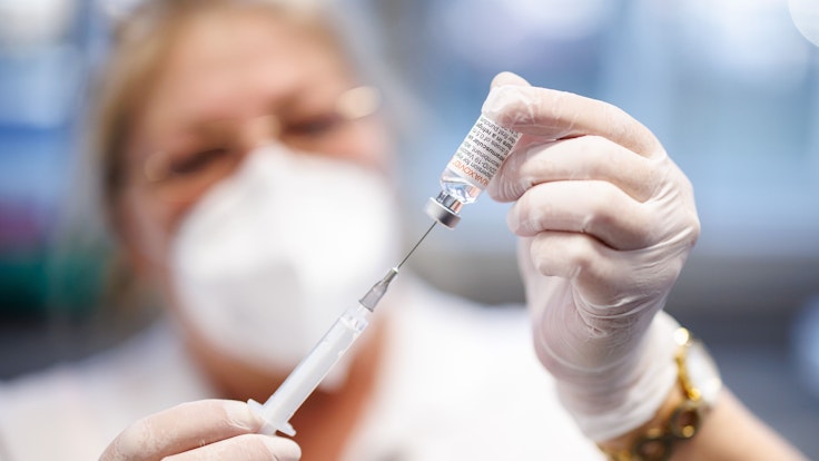 Eine Krankenschwester zieht im Impfzentrum Freising den Impfstoff Nuvaxovid vom Hersteller Novavax auf eine Spritze auf.