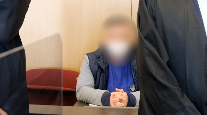 Ein Angeklagter sitzt flankiert von seinen Anwälten auf der Anklagebank des Landgerichts Düsseldorf.