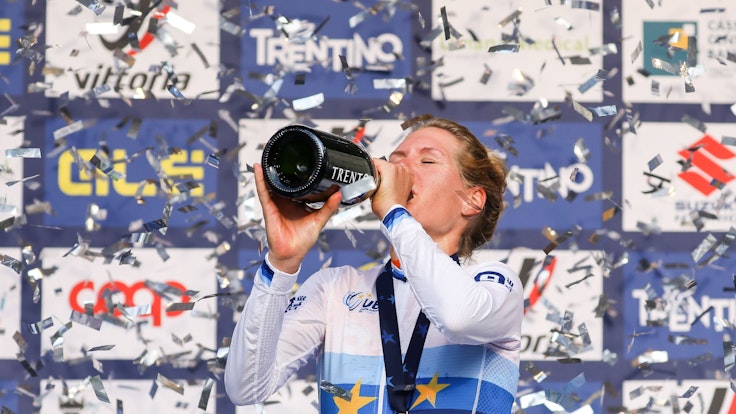 Ellen van Dijk aus den Niederlanden trinkt auf dem Siegerpodium Champagner.