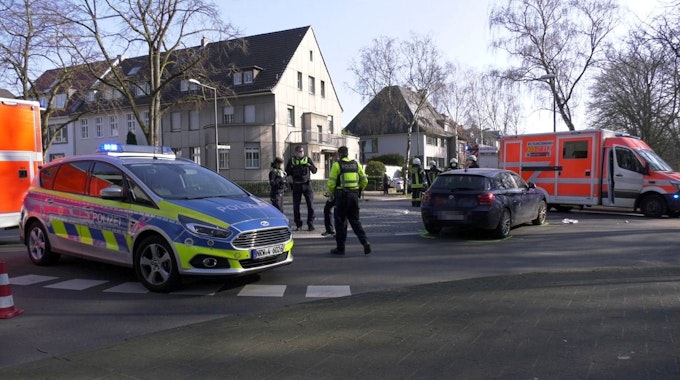 Polizisten stehen nach einem Unfall auf einer Straße in Köln.