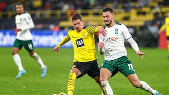 Gladbach-Verteidiger Ramy Bensebaini (r.) im Duell mit Thorgan Hazard (l.) von Borussia Dortmund am 20. Februar 2022 im Signal-Iduna-Park. Hazard behauptet den Ball.