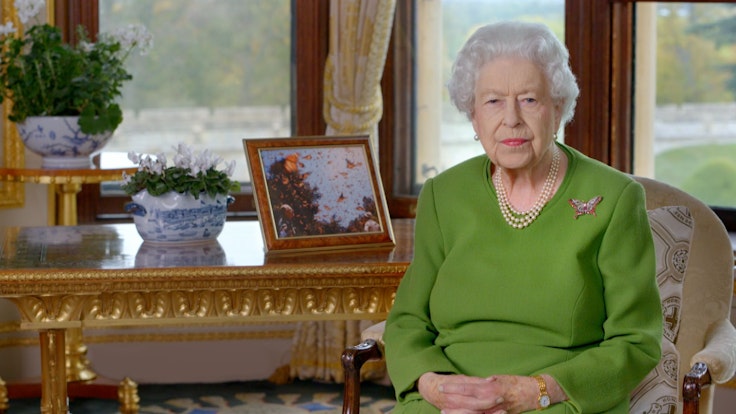 Königin Elizabeth II.posiert auf einem Stuhl für ein Foto.