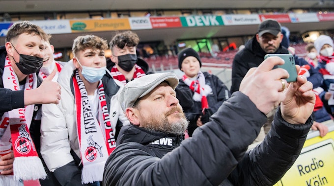 Kölns Trainer Steffen Baumgart macht nach dem Spiel ein Selfie mit den Fans.