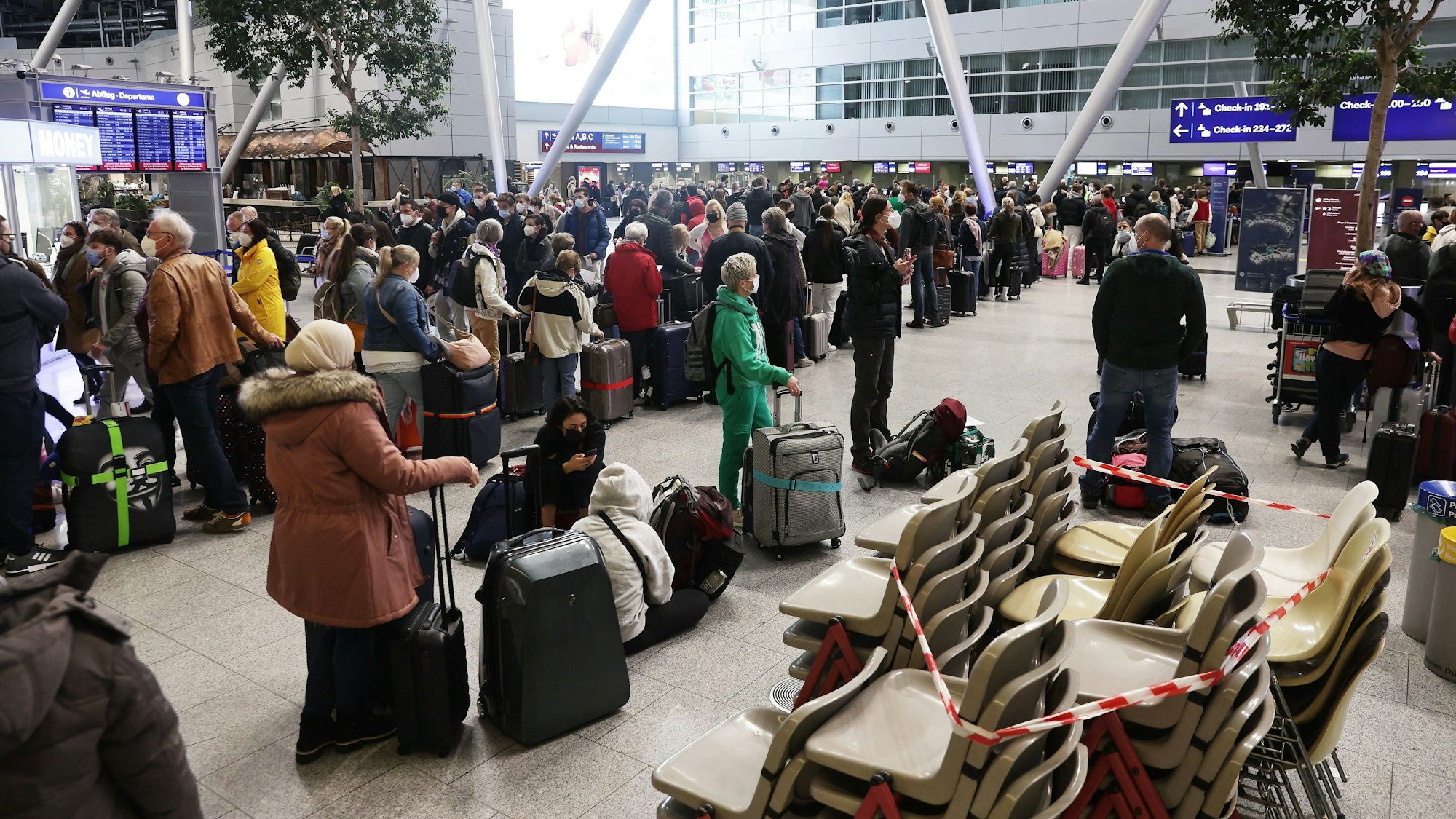 Fluggäste stehen in der Abfertigungshalle am Flughafen Düsseldorf. Dortmusste die Bundespolizei beim Fall einer 60-jährigen Frau einschreiten.