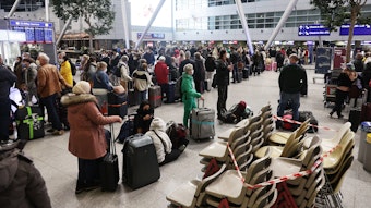 Fluggäste stehen in der Abfertigungshalle am Flughafen Düsseldorf. Dortmusste die Bundespolizei beim Fall einer 60-jährigen Frau einschreiten.