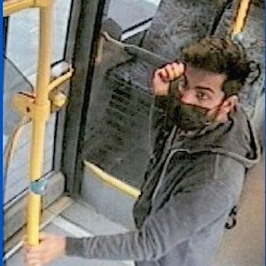 Ein Mann steht im Bus an der Tür.