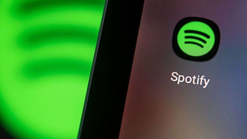 Auf dem Bildschirm eines Smartphones sieht man das Logo der App Spotify.