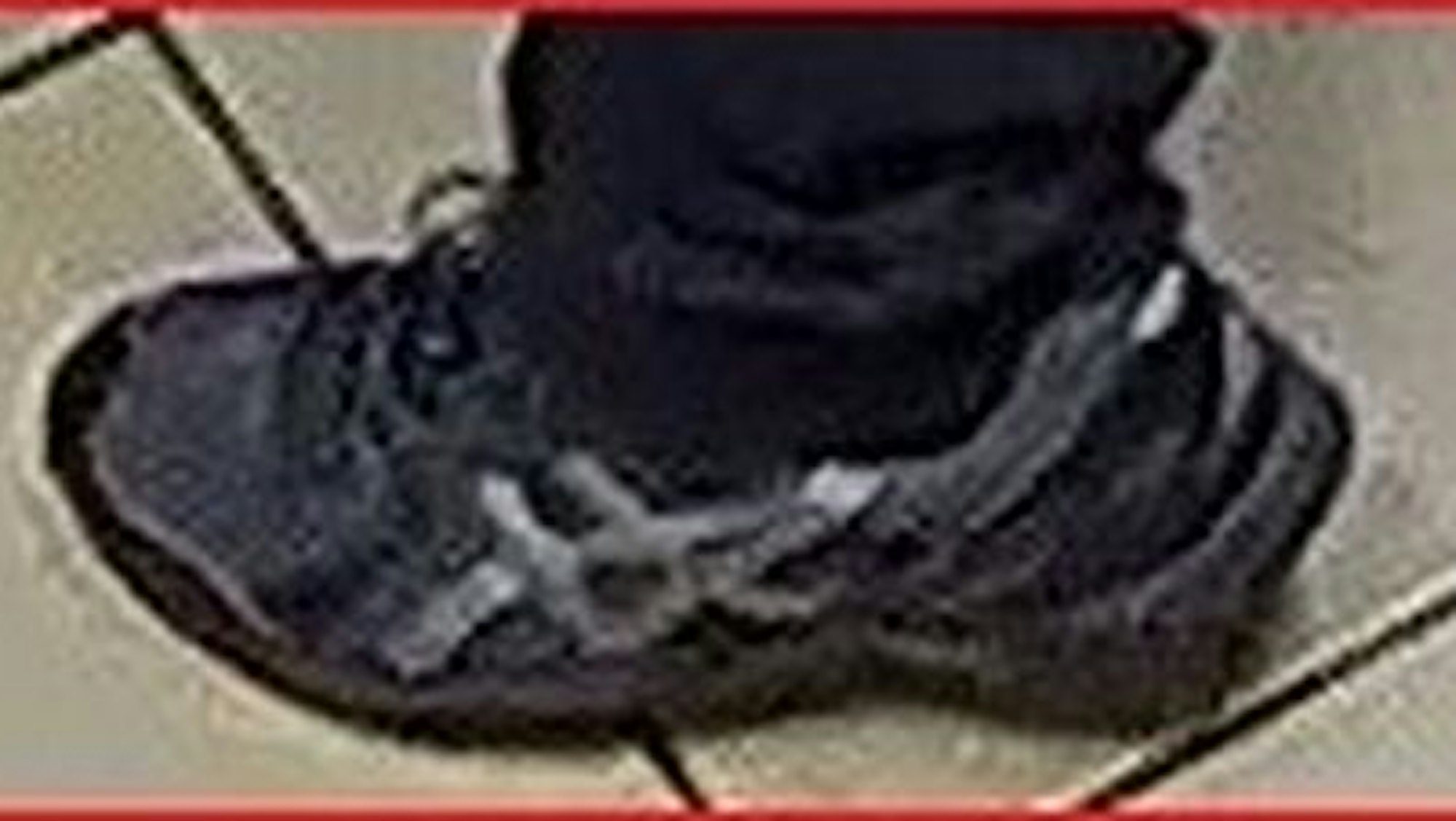 Schwarze Schuhe der Marke Asics auf einem Fahndungsfoto.
