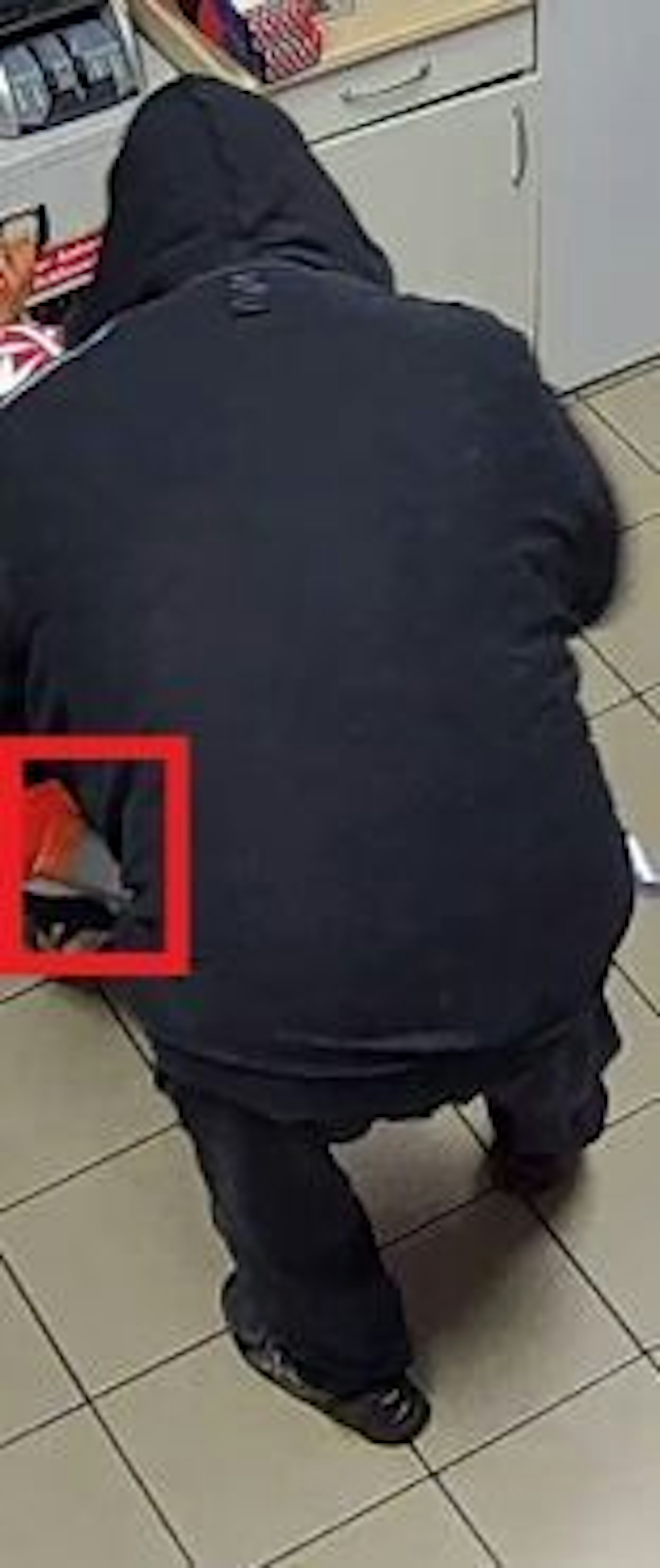 Fahndungsfoto eines Mannes, der eine Frau mit einer Waffe bedroht.