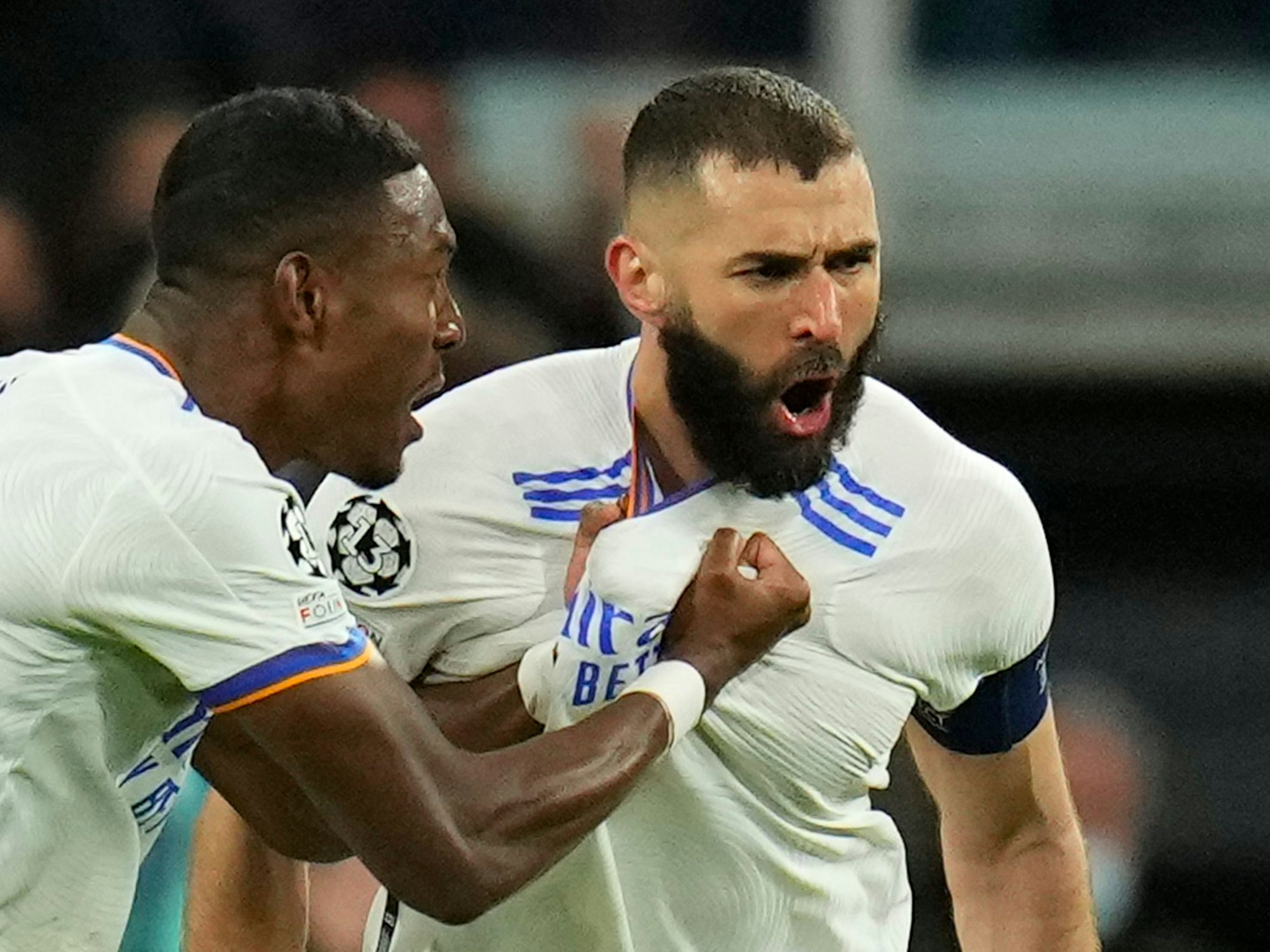 Real Madrid's David Alaba celebrates with Karim Benzema, right, who scored his side's first goal during the Champions League, round of 16, second leg soccer match between Real Madrid and Paris Saint-Germain at the Santiago Bernabeu stadium in Madrid, Spain, Wednesday, March 9, 2022. (AP Photo/Manu Fernandez)