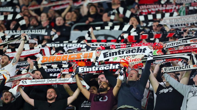 Frankfurt-Fans halten ihre Schals in die Luft.