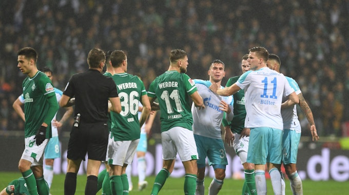 Nach einem Foul an Werders Ömer Toprak gibt es eine Auseinandersetzung zwischen den Spielern, vor allem Werders Niclas Füllkrug (M) und Schalkes Marius Bülter (r).