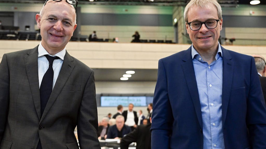 Die beiden Kandidaten für das Amt des DFB-Präsidenten, Bernd Neuendorf (l) und Peter Peters stehen vor der Versammlung zusammen.