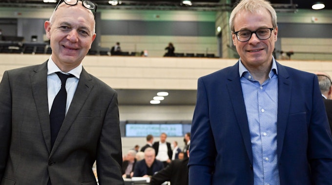 Die beiden Kandidaten für das Amt des DFB-Präsidenten, Bernd Neuendorf (l) und Peter Peters stehen vor der Versammlung zusammen.