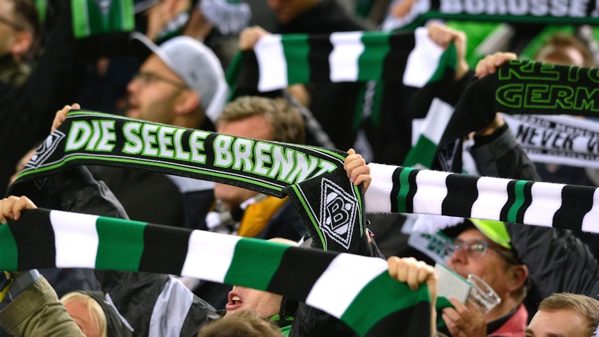Fans von Fußball-Bundesligist Borussia Mönchengladbach, hier zu sehen während des Europa-League-Spiels gegen AS Rom am 7. November 2019. Die Fans strecken ihre Schals in die Luft.
