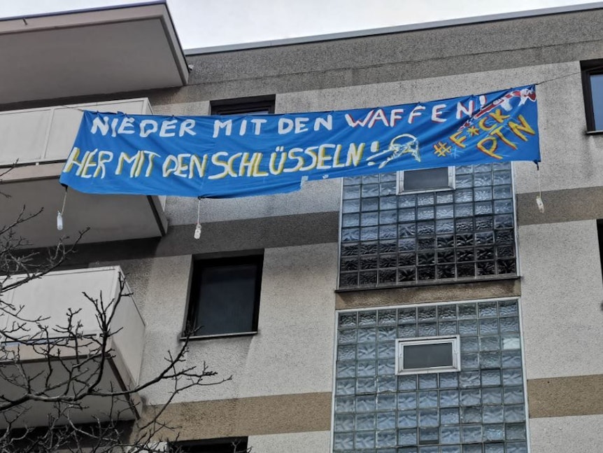 Unter anderem wurde dieses Transparent mit der Aufschrift „Nieder mit den Waffen! Her mit den Schlüsseln!“ am Gebäude befestigt, um auf den Wohnungsmissstand in Köln aufmerksam zu machen.