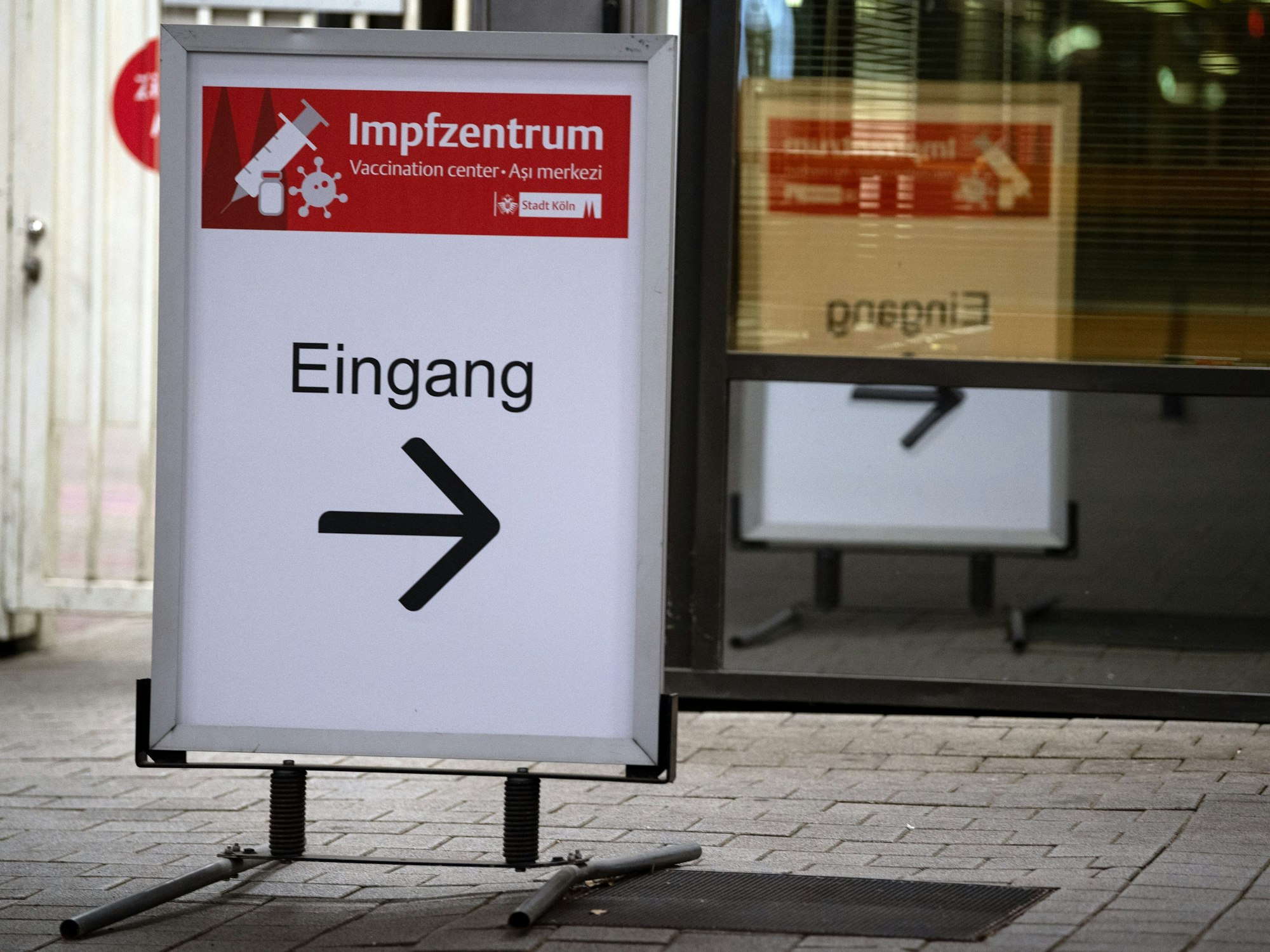 Schild weist Eingang zu einem Impfzentrum in Köln.