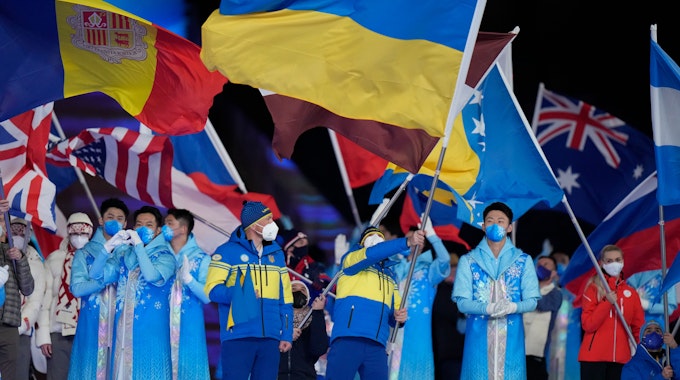 Der Fahnenträger der Ukraine schwenkt bei der Abschlussfeier der Paralympics die Landesflagge