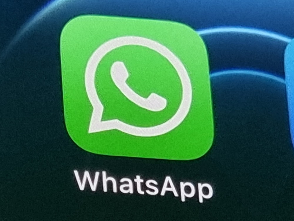 Das Logo des Nachrichtendienstes WhatsApp wird auf dem Display eines Smartphones angezeigt.