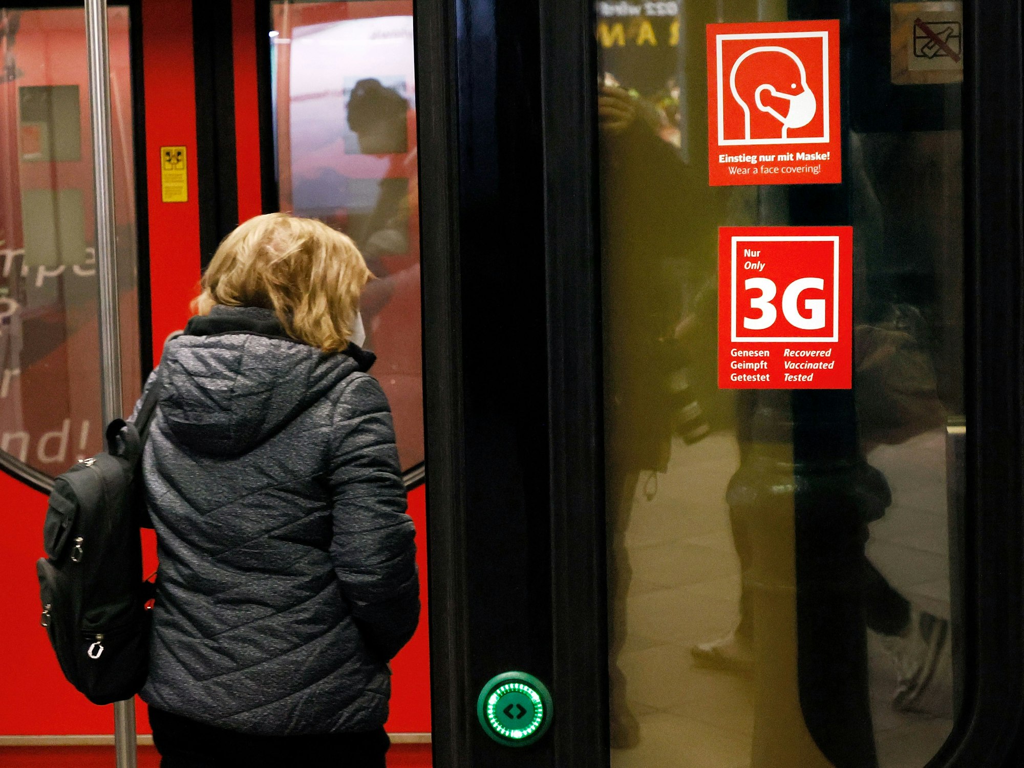 Ein Fahrgast betritt im Januar eine Bahn in Berlin, an der Schildern mit dem Hinweis auf die Masken- und 3-G-Regeln zu sehen sind. Die Maskenpflicht soll nun doch ausgeweitet werden.