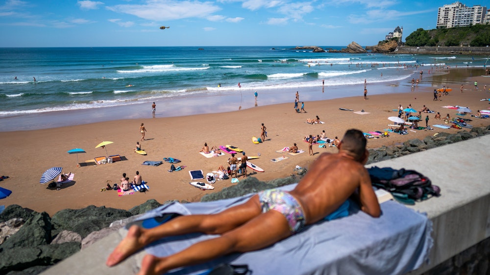 Urlauber entspannen am Strand von Biarritz in Frankreich.