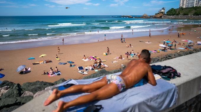 Urlauber entspannen am Strand von Biarritz in Frankreich.