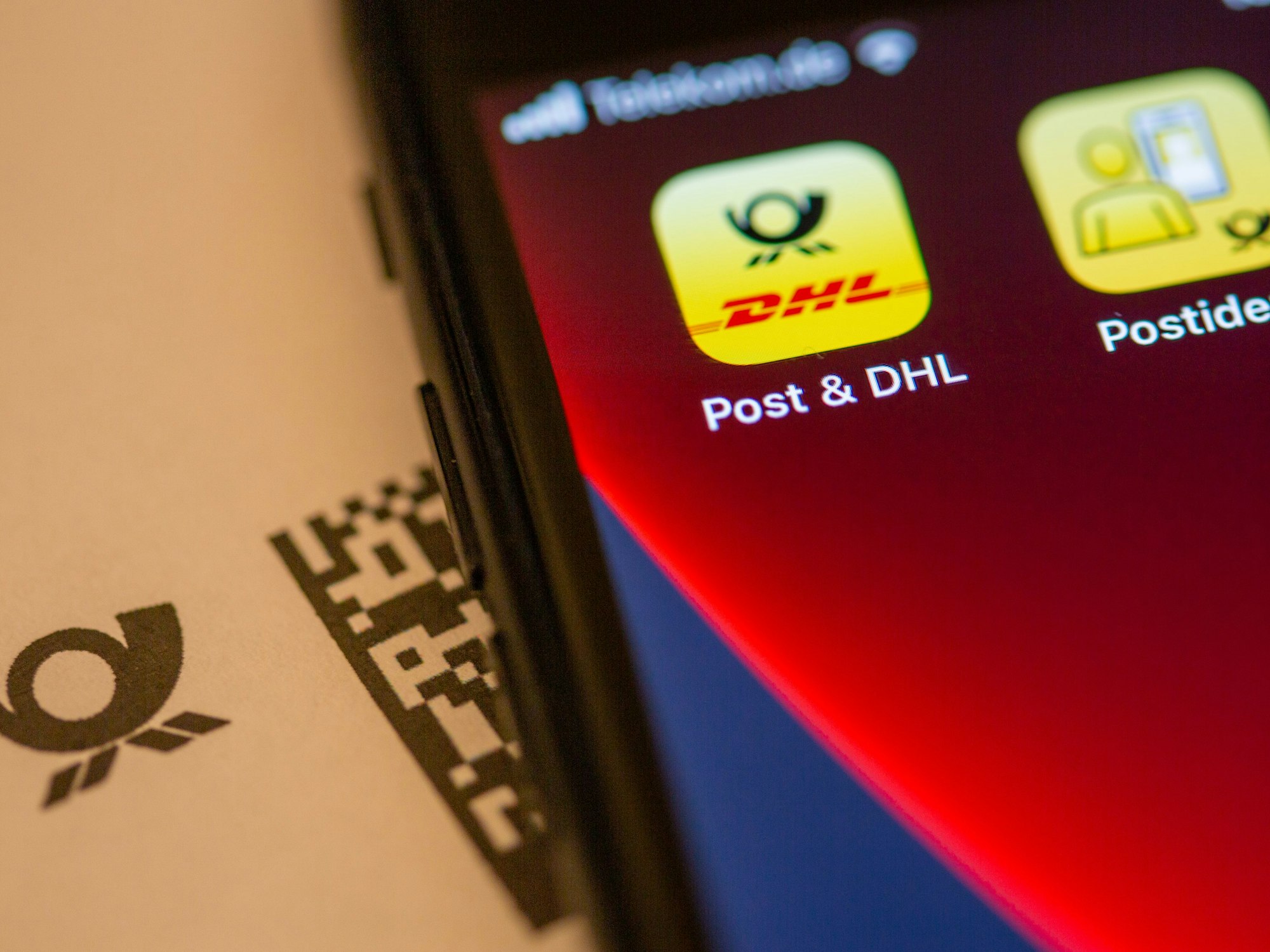 Das Logo der „Post & DHL“-App ist auf dem Display eines Smartphones zu sehen.