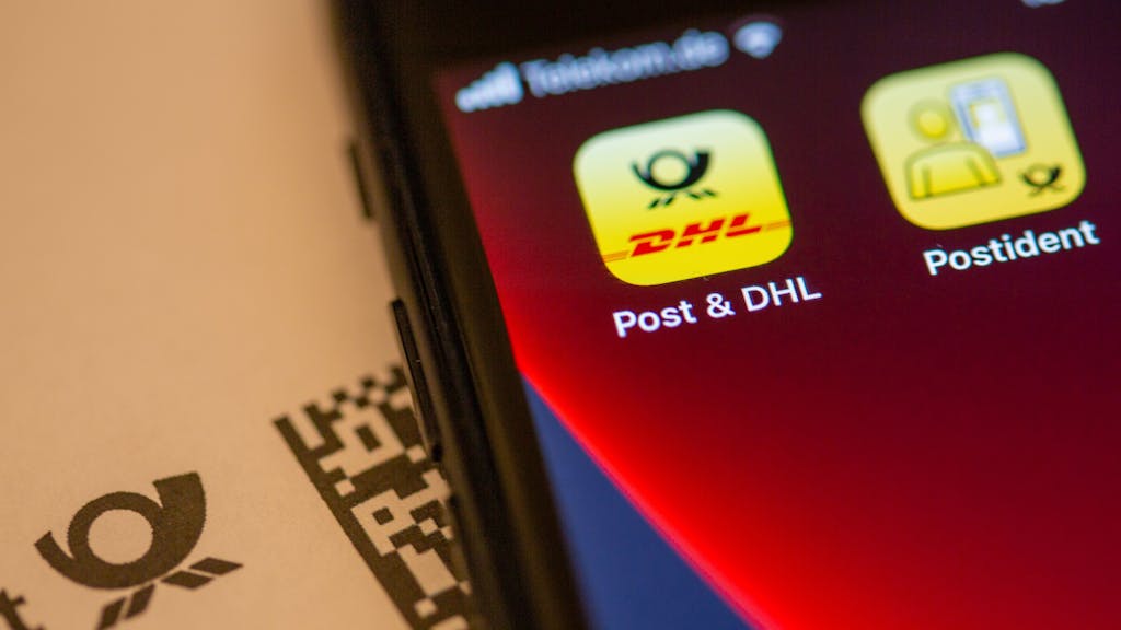 Das Logo der Post &amp; DHL App ist auf dem Display eines Smartphones zu sehen.