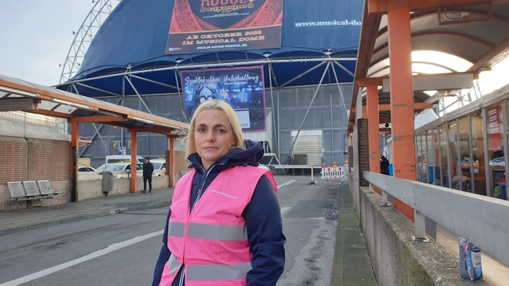 Inga Weber steht vor dem Musical Dome am Breslauer Platz und neben der neuen Anlaufstelle für Geflüchtete aus der Ukraine.