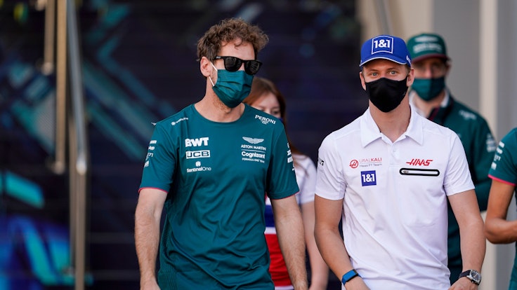 Sebastian Vettel (l) aus Deutschland und Mick Schumacher aus Deutschland vom Team Haas treffen an der Rennstrecke ein. Der Große Preis von Abu Dhabi findet am 12. Dezember 2021 statt.