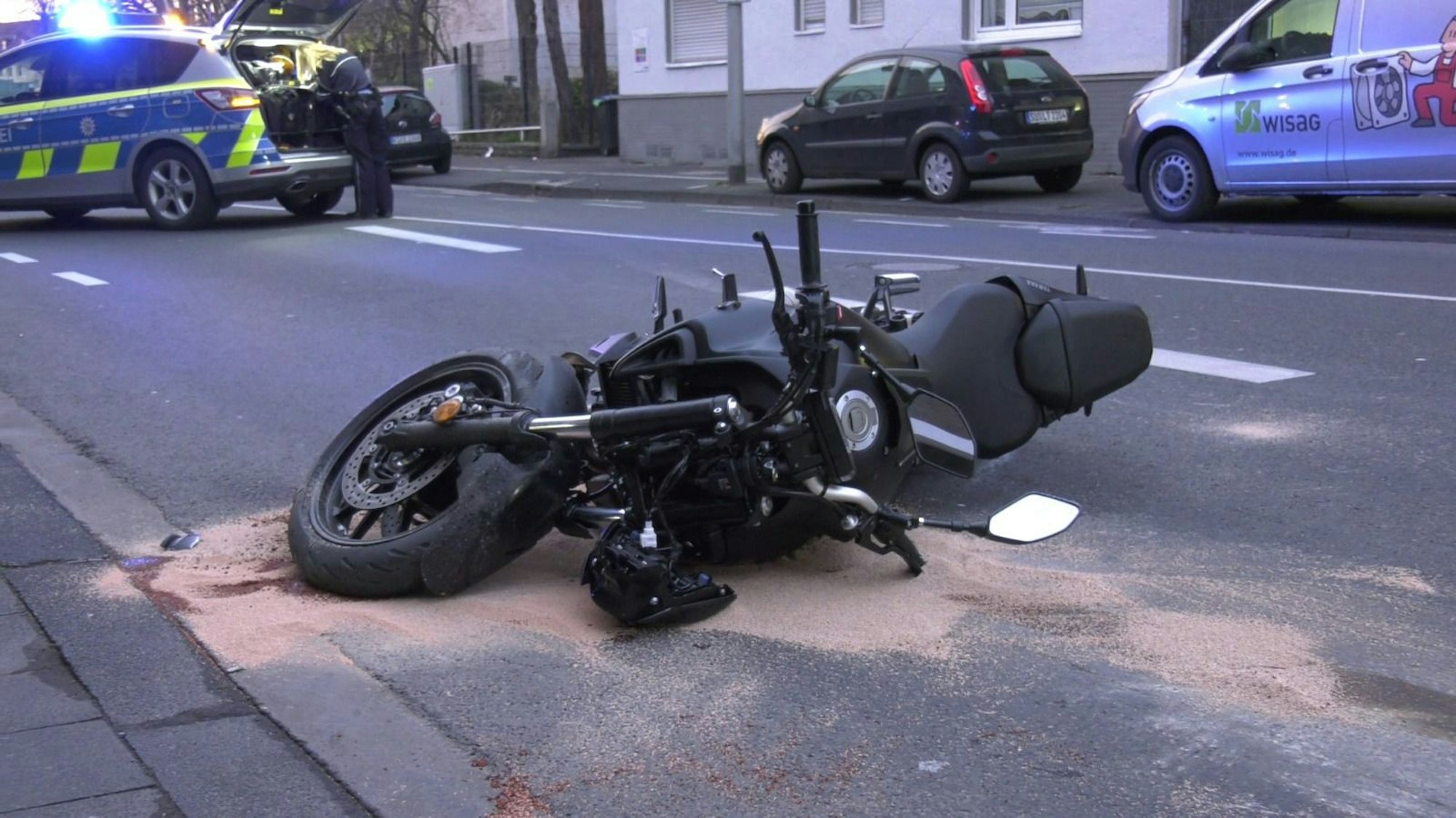 Das Motorrad der jungen Frau liegt nach dem Unfall in Köln auf der Straße.