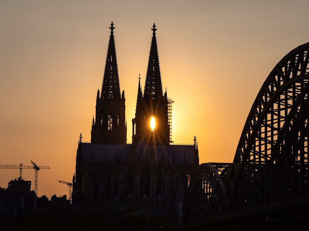 Ein Sonnenuntergang in Köln mit Blick auf den Dom. Ein spezieller Köln-Anstecker sorgt jetzt für Lacher.