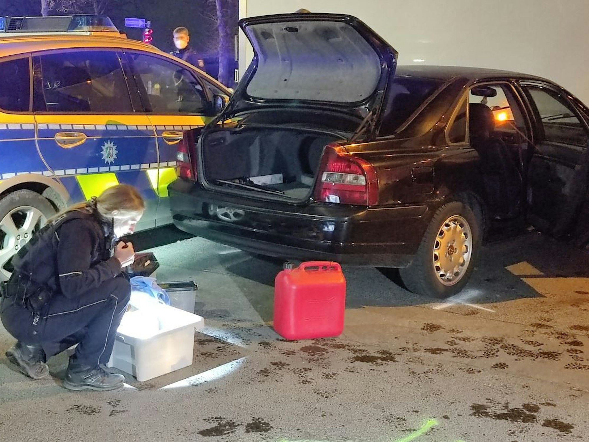 Eine Polizistin kontrolliert eine Kiste, die sich im Kofferraum des Volvos befand. Nach einer Verfolgungsjagd wurde der Wagen in Köln-Bayenthal gestoppt.