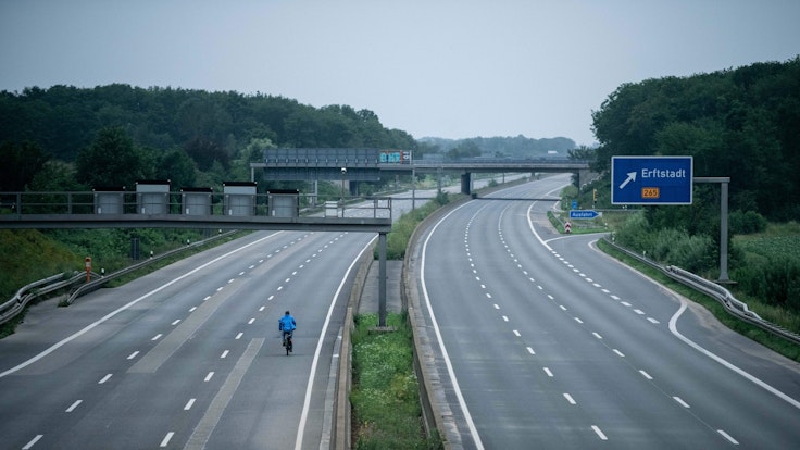 Ein Fahrradfahrer fährt über die gesperrte Autobahn A1 nahe Blessem in Erftstadt.