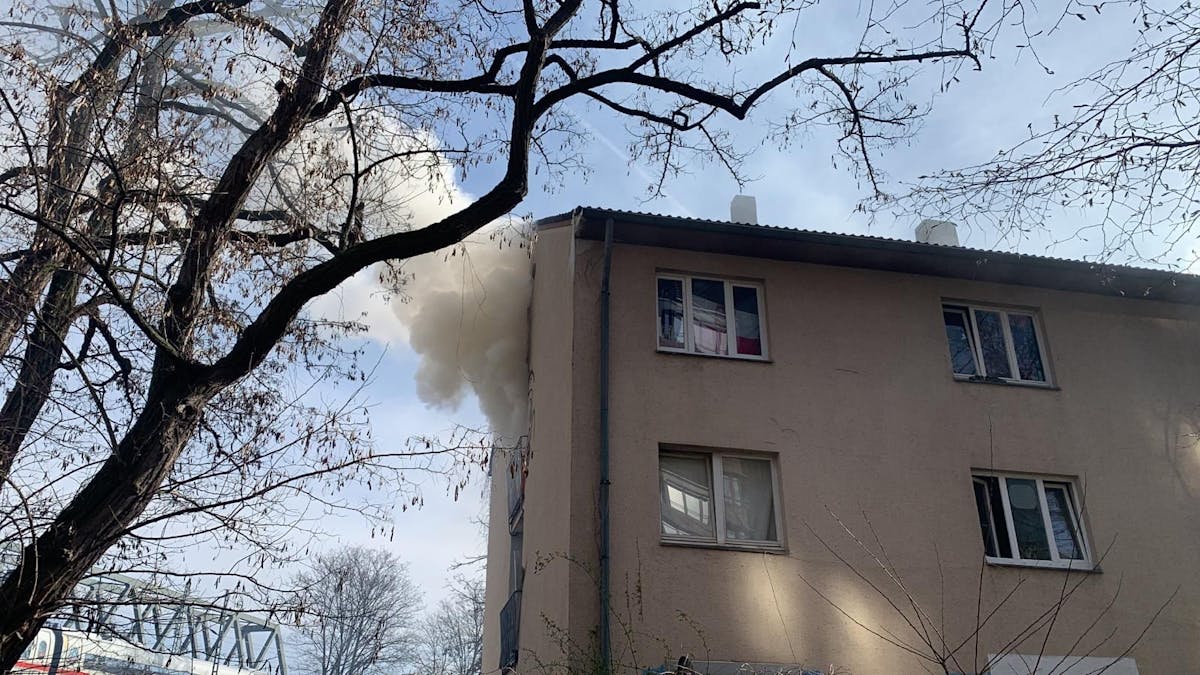 Nach einem Feuer in einem Gebäude dringt Rauch aus einem Fenster.