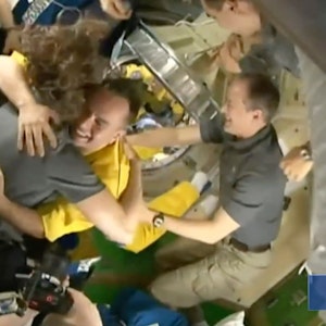 In diesem von Roskosmos zur Verfügung gestellten Video begrüßt die Besatzung der Internationalen Raumstation (ISS) drei russische Kosmonauten in gelber Kleidung, nachdem die Neuankömmlinge angedockt haben.