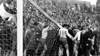 Am 3. April 1971 bricht bei der Bundesliga-Partie zwischen Borussia Mönchengladbach und dem SV Werder Bremen auf dem Gladbacher Bökelberg der Torpfosten. Auf diesem Foto versuchen Bremer Spieler, dass Tor wieder aufzurichten. Sie drücken und schieben.