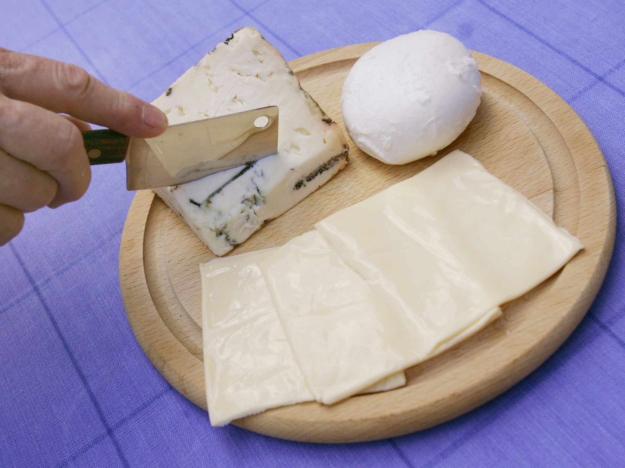 Unser Symbolbild zeigt Ein Stück Gorgonzola, ein Bällchen Mozzarella und drei Scheibletten Käse. Ein Mozzarella wird zurückgerufen, weil scharfkantige Kunststoffstückchen enthalten sein könnten.