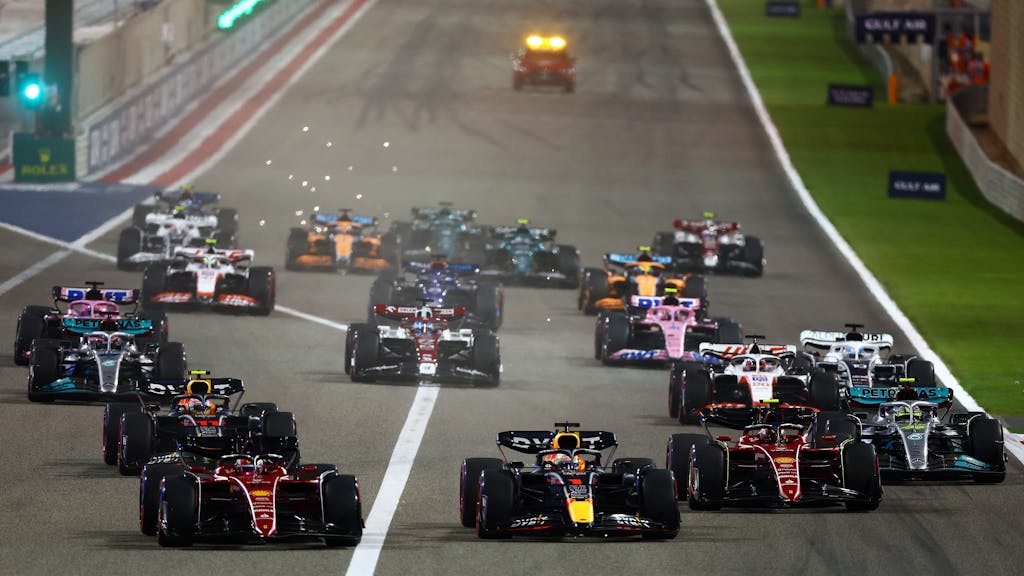 BAHRAIN, BAHRAIN - MARCH 20: Charles Leclerc of Monaco driving (16) the Ferrari F1-75 leads Max Verstappen of the Netherlands driving the (1) Oracle Red Bull Racing RB18 and the rest of the field going into the first corner at the start of the race during the F1 Grand Prix of Bahrain at Bahrain International Circuit on March 20, 2022 in Bahrain, Bahrain. (Photo by Mark Thompson/Getty Images)